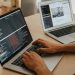 A developer working on a laptop, typing code, showcasing programming and technology skills.