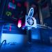 A close-up of an illuminated 3D printer in action, highlighting modern technology.