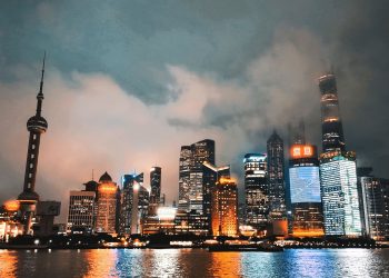 Captivating view of Shanghai's illuminated skyline reflecting on the Huangpu River at night.