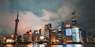 Captivating view of Shanghai's illuminated skyline reflecting on the Huangpu River at night.
