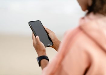 Close-up of a person using a smartphone outdoors, focusing on modern technology.