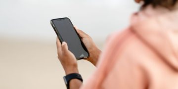 Close-up of a person using a smartphone outdoors, focusing on modern technology.