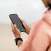 Close-up of a person using a smartphone outdoors, focusing on modern technology.
