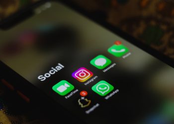 A close-up shot of smartphone displaying social media apps icons on screen.