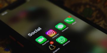 A close-up shot of smartphone displaying social media apps icons on screen.