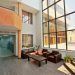 A spacious, modern lobby with high ceilings, large windows, and contemporary furniture.