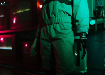 A cyberpunk setting featuring a person with a robotic arm amidst neon and retro elements.