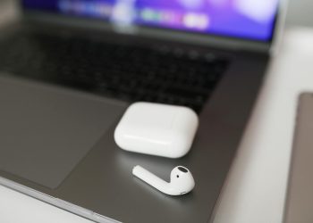 A close-up shot of wireless earbuds and case on a laptop, perfect for tech themes.