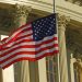 US flag waving outside the iconic US Capitol Building in Washington, DC.