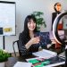 Asian woman discussing cryptocurrency investment during a vlogging session with charts.