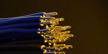 Detailed view of blue ethernet cables with exposed gold-plated conductors.