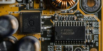 Detailed view of microchips and components on a motherboard circuit board.