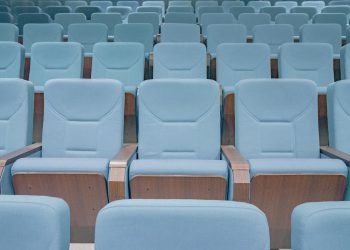 Rows of modern blue theater seats in an empty auditorium, highlighting architectural design.