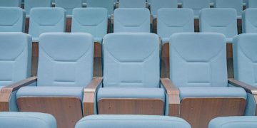 Rows of modern blue theater seats in an empty auditorium, highlighting architectural design.