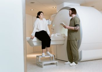 A patient consults with a technician in a modern MRI room, highlighting advanced healthcare facilities.