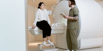 A patient consults with a technician in a modern MRI room, highlighting advanced healthcare facilities.