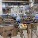 Water bottles being processed on an automated conveyor in a modern factory setting.