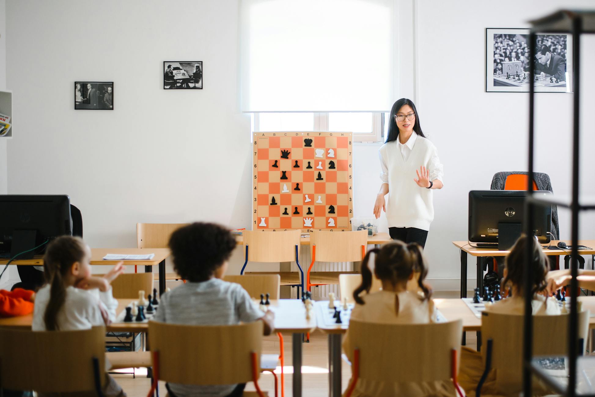 A teacher instructs students in a chess classroom, enhancing strategic thinking skills.