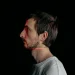 Side profile of a man with red laser scanning lines on his face on a black background.