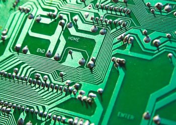 Detailed view of green circuit board with visible chips and pathways, highlighting technology elements.