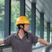 Construction worker in a hard hat examines an industrial site, showcasing safety and industry.