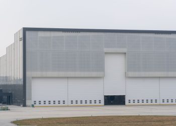 Front view of a large modern warehouse with closed doors, showcasing industrial architecture