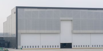 Front view of a large modern warehouse with closed doors, showcasing industrial architecture