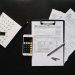 Flat lay of financial tools for tax preparation including forms, calculator, and calendar.
