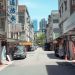 A typical street scene in Taipei, featuring local shops and a view of city buildings.