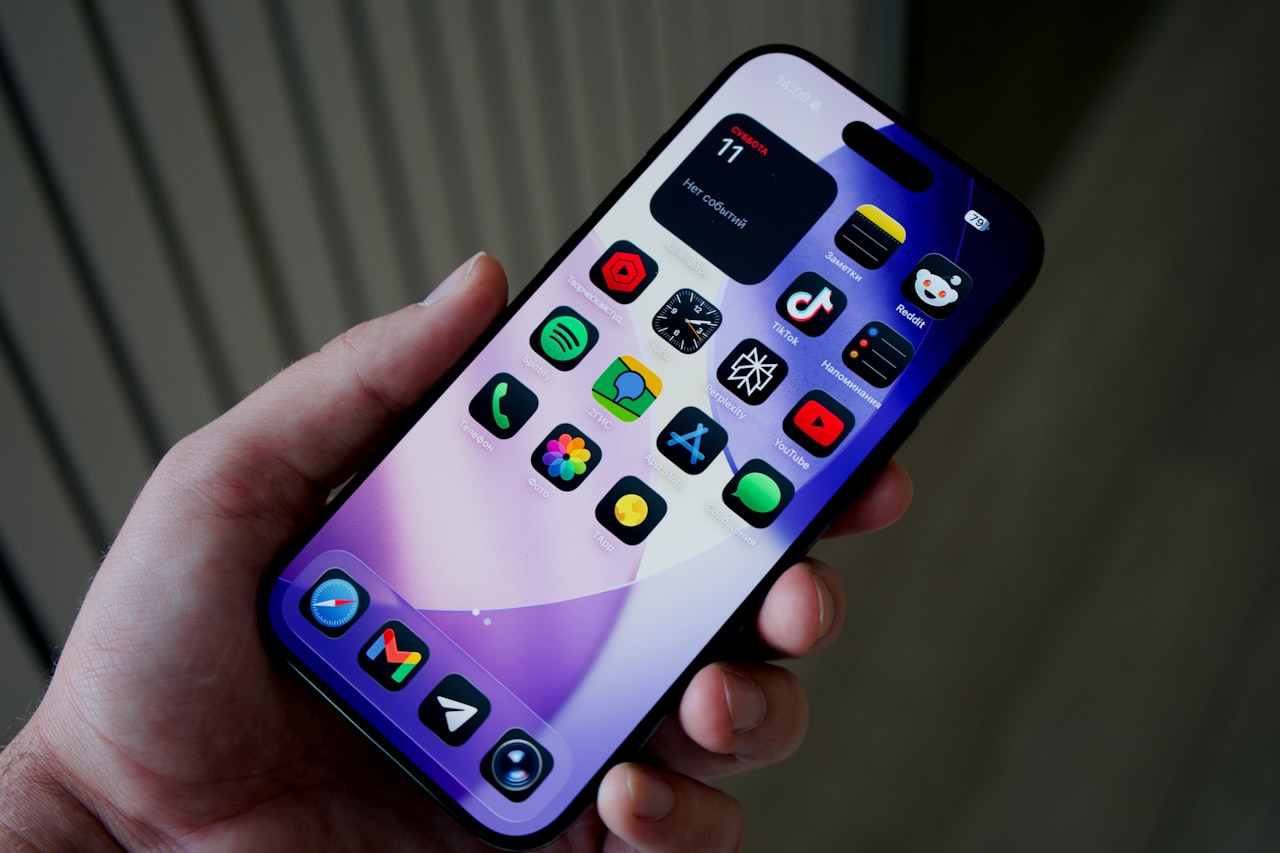 Hand holding smartphone with colorful app icons