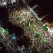 A lively aerial view of a crowded nighttime street festival with illuminated streets.