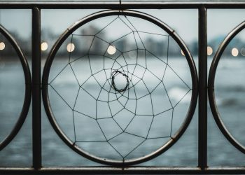 A close-up of an iron railing featuring a circular geometric design, offering a modern abstract aesthetic.