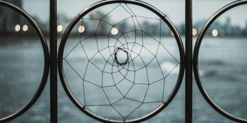 A close-up of an iron railing featuring a circular geometric design, offering a modern abstract aesthetic.