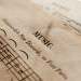 Detailed view of antique music sheets featuring notes and Monteverde's New Discords in sepia tone.