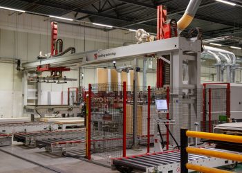 Industrial machinery with robotic arm in a modern manufacturing facility.