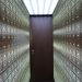 Wooden lockboxes line the walls of a modern, secure vault with a central wooden door.