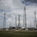 Industrial rocket launch pad with tall towers under a cloudy sky, perfect for technology and energy themes.