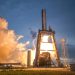 A dramatic shot of a SpaceX rocket launch against a colorful dusk sky, depicting power and technology.