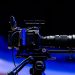 Side view of a professional video camera with lens on a tripod, ready for filming.