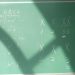 Algebra equations with symbols on a chalkboard in a brightly lit classroom.
