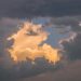 A captivating cloudscape featuring golden clouds illuminated by the setting sun, creating a serene and ethereal atmosphe