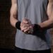 Close-up of a person's muscular arms with clasped hands, conveying strength and focus.