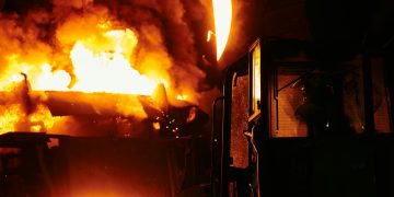 A dramatic scene of molten steel pouring in an industrial setting during nighttime.