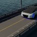 A futuristic car driving on a bridge over a body of water