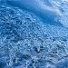 Detailed view of intricate ice patterns on a frozen surface in winter.