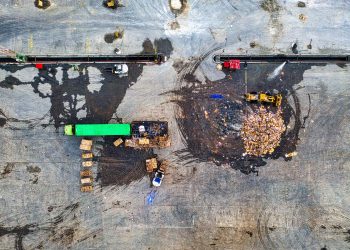 Aerial shot of waste processing site with heavy equipment and trucks in Serang, Indonesia.