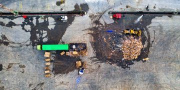 Aerial shot of waste processing site with heavy equipment and trucks in Serang, Indonesia.