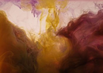Colorful abstract ink patterns swirling in water create a mesmerizing visual effect.