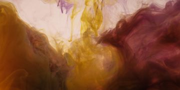 Colorful abstract ink patterns swirling in water create a mesmerizing visual effect.