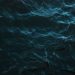 Mysterious dark ocean surface with subtle light reflections and deep blue hues.
